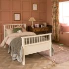 ivory white single bed with dressing table in kids bedroom with terracotta panelled wall 