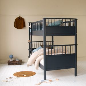 Navy blue Scandinavian bunk bed with spindles in a neutral bedroom with picture rail, shirt hanging, toys and battered suitcase 