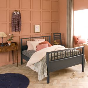 Painswick blue small double bed with spindles, antique dressing table next to it, dress hanging on wall and teddy on blue chair 