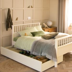 Cream and green bedroom with small double bed, striped bedding and panelled wall